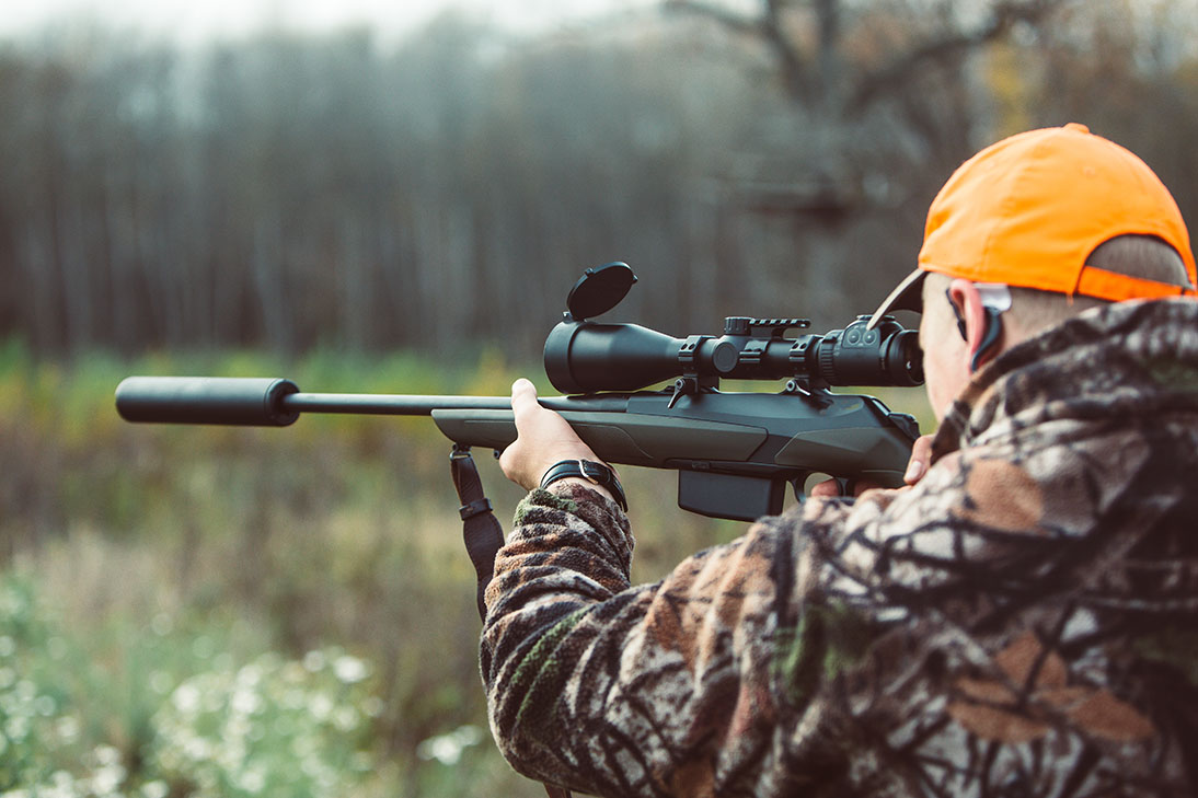 Hunter hold rifle and aiming to deer. Hunting optics equipment Animal